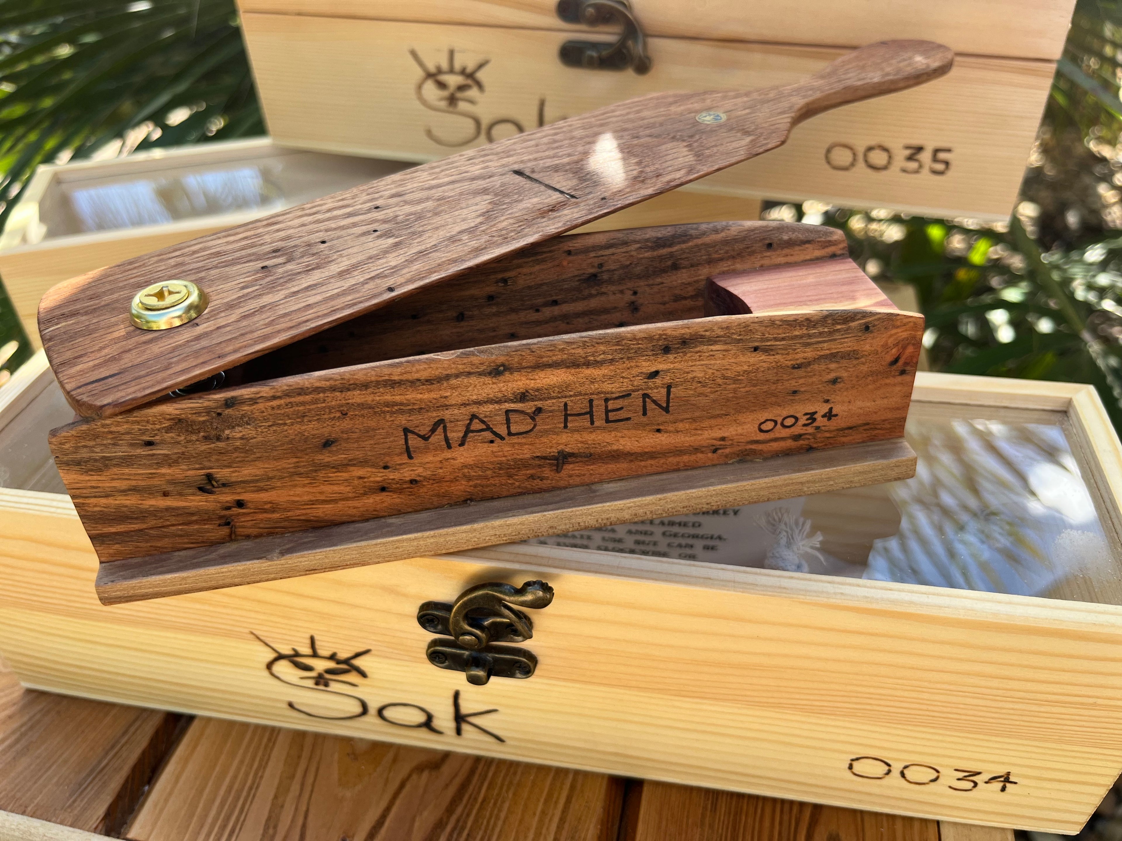Wooden product with 'MAD HEN' engraving on a wooden box with 'Sak' branding.